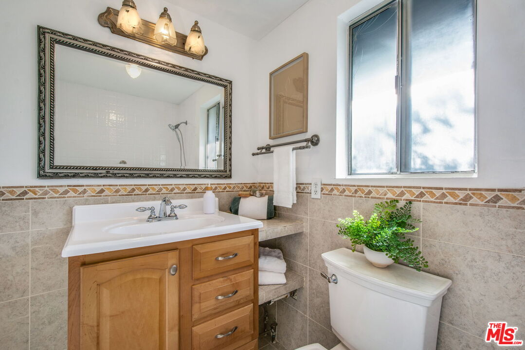 2142 West 11th Street Santa Ana, CA 92703 - Photo 37 of 54 a bathroom with a sink vanity mirror and toilet