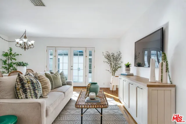 a living room with furniture a chandelier and a flat screen tv