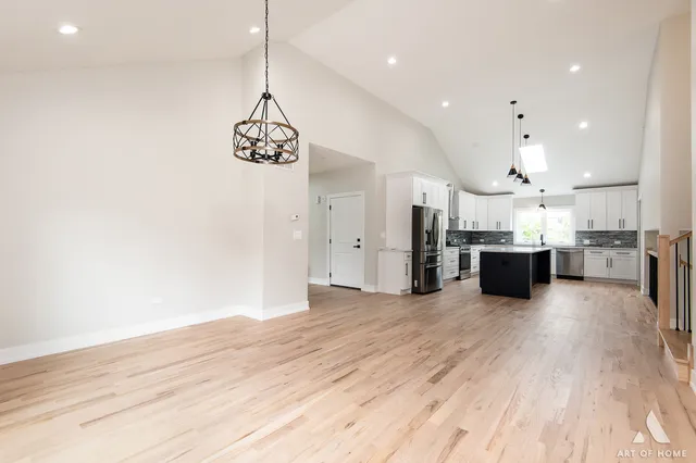 a view of a kitchen with kitchen island a sink stainless steel appliances and cabinets