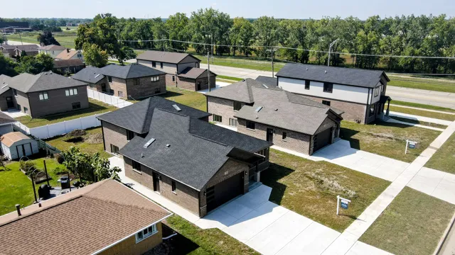 an aerial view of a house with a garden and lake view