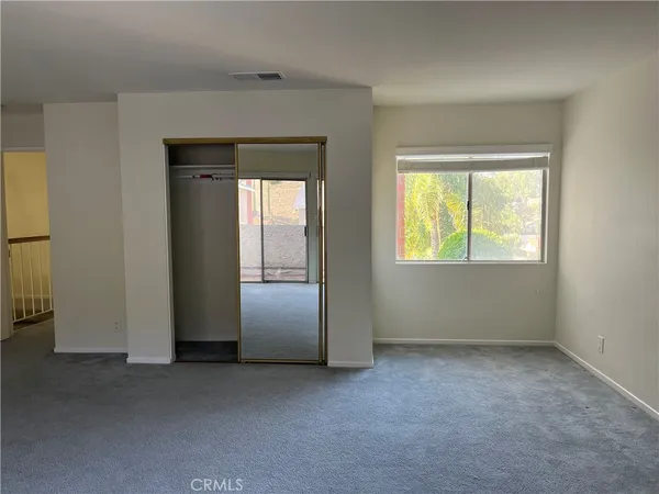 an empty room with windows and closet