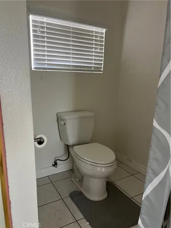 a bathroom with a toilet a sink and a window