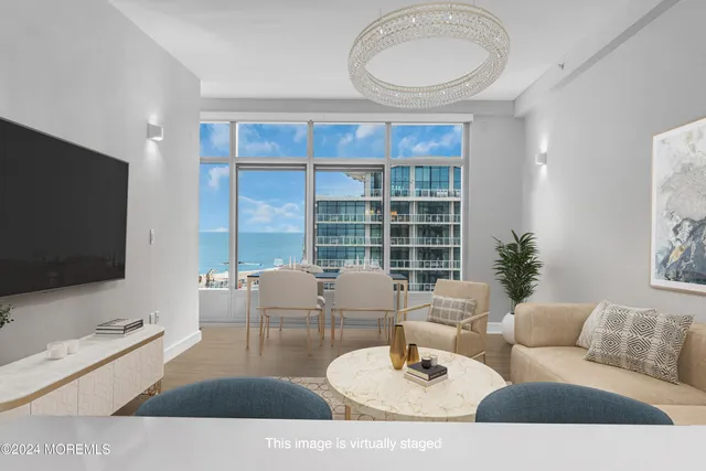 a living room with furniture a floor to ceiling window and a flat screen tv