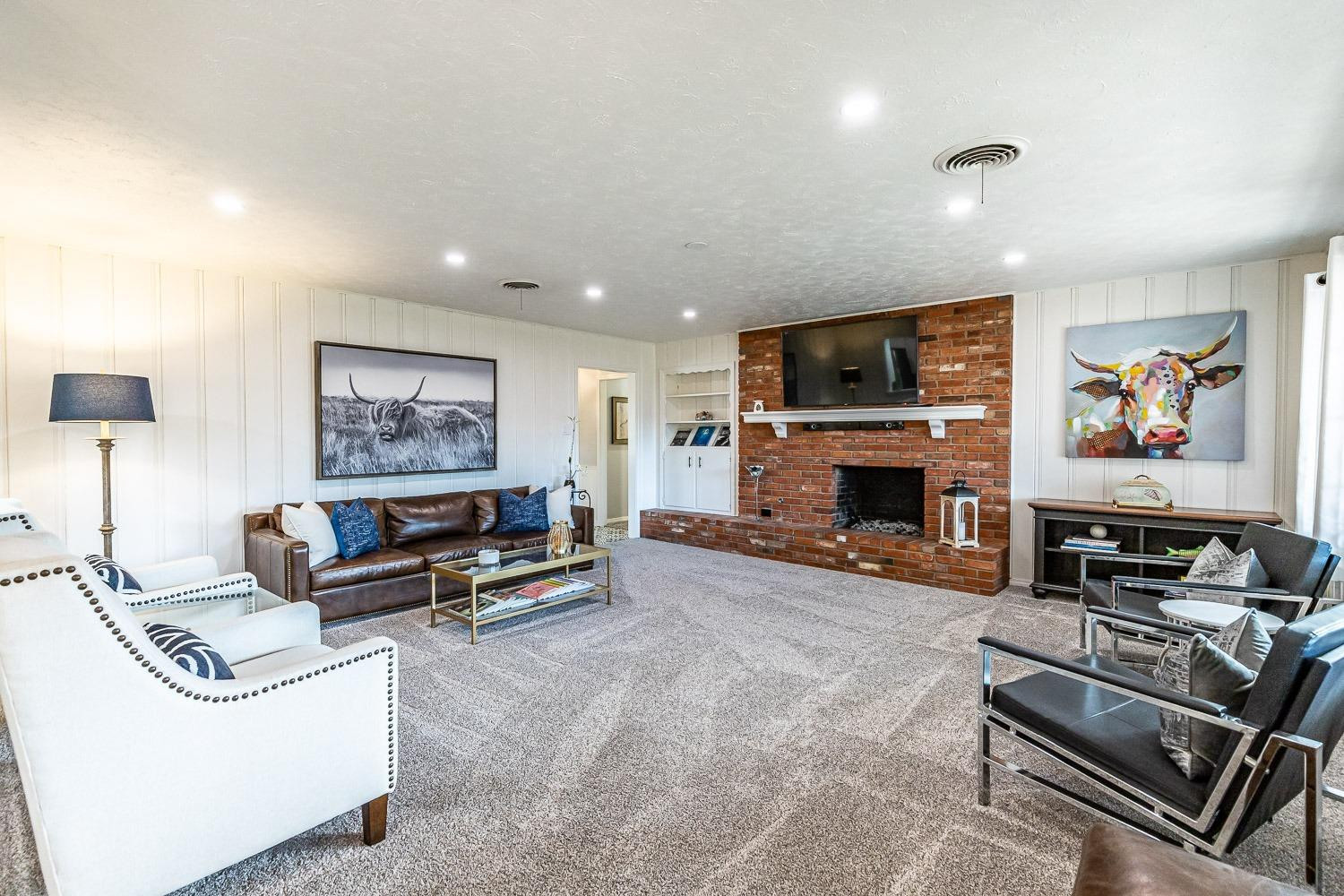 3417 61st Street Lubbock, TX 79413 - Photo 11 of 39 a living room with furniture a flat screen tv and a fireplace