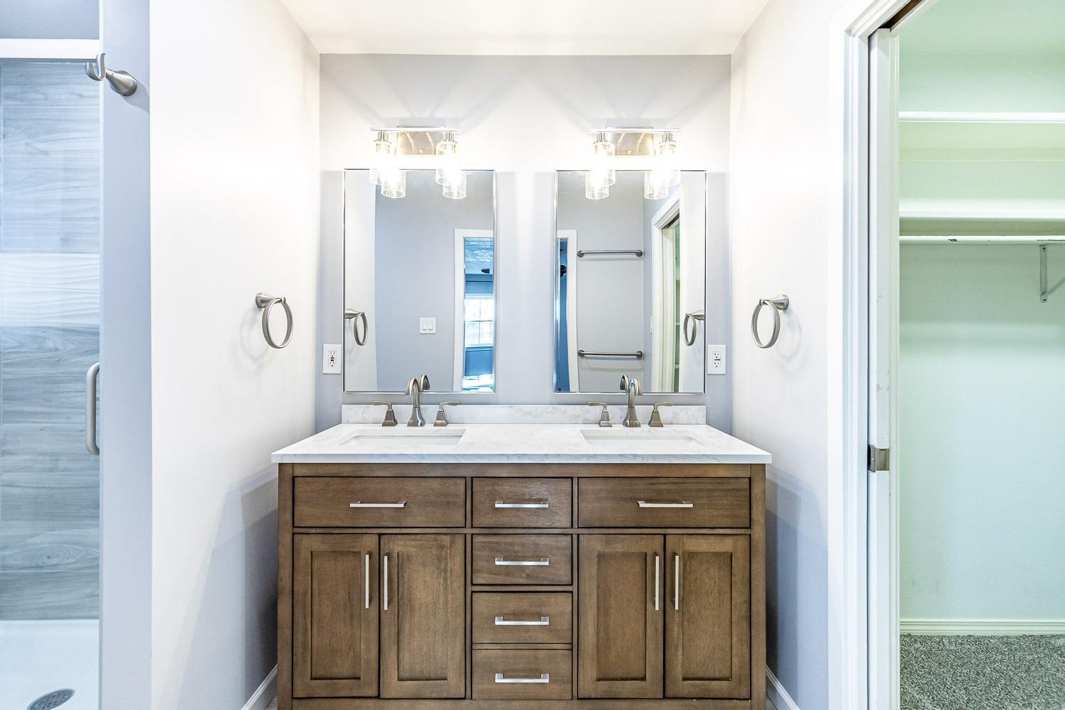 3417 61st Street Lubbock, TX 79413 - Photo 21 of 39 a bathroom with a double vanity sink and mirror