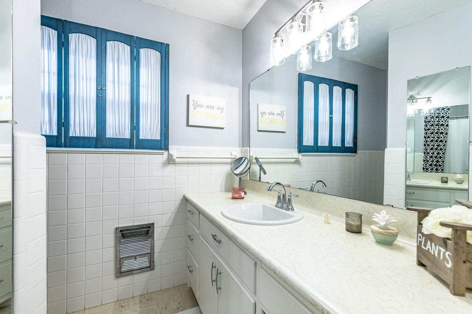 3417 61st Street Lubbock, TX 79413 - Photo 29 of 39 a bathroom with a sink a vanity and a mirror