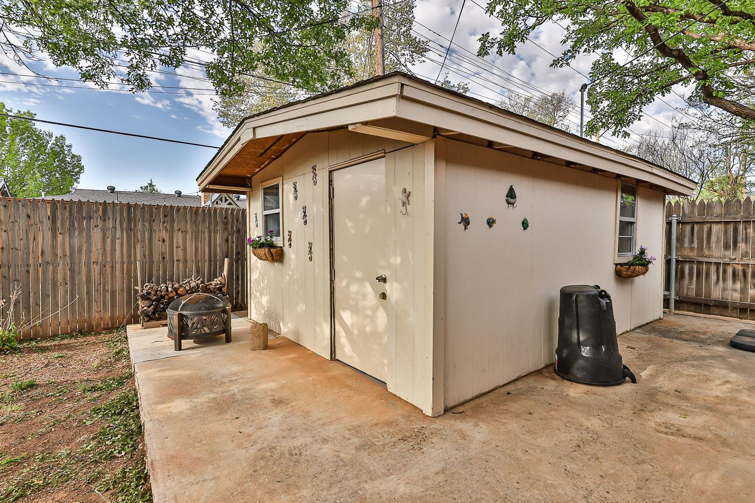 3417 61st Street Lubbock, TX 79413 - Photo 38 of 39 a backyard of a house with a bench and wooden fence
