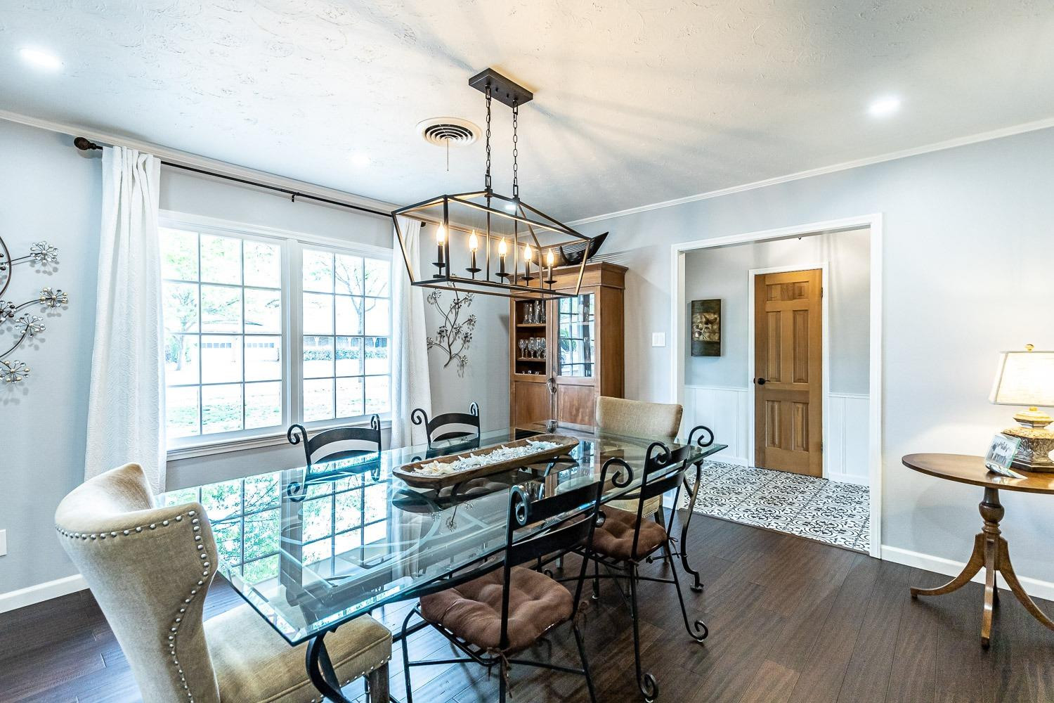 3417 61st Street Lubbock, TX 79413 - Photo 7 of 39 a dining room with furniture a chandelier and wooden floor