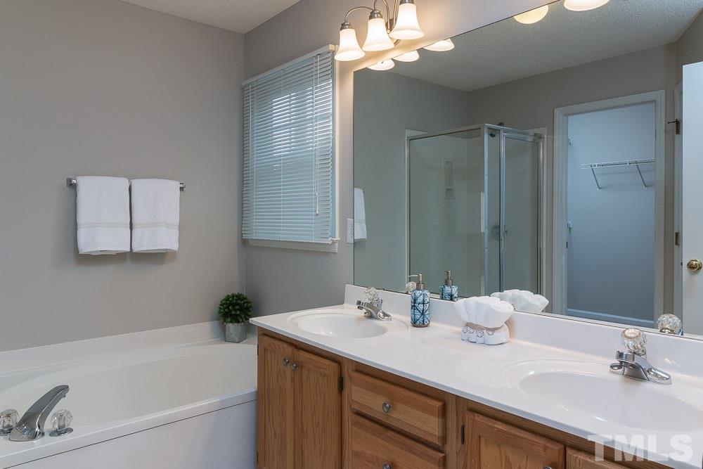 12404 Harcourt Drive Raleigh, NC 27613 - Photo 14 of 22 a bathroom with a tub a sink and mirror