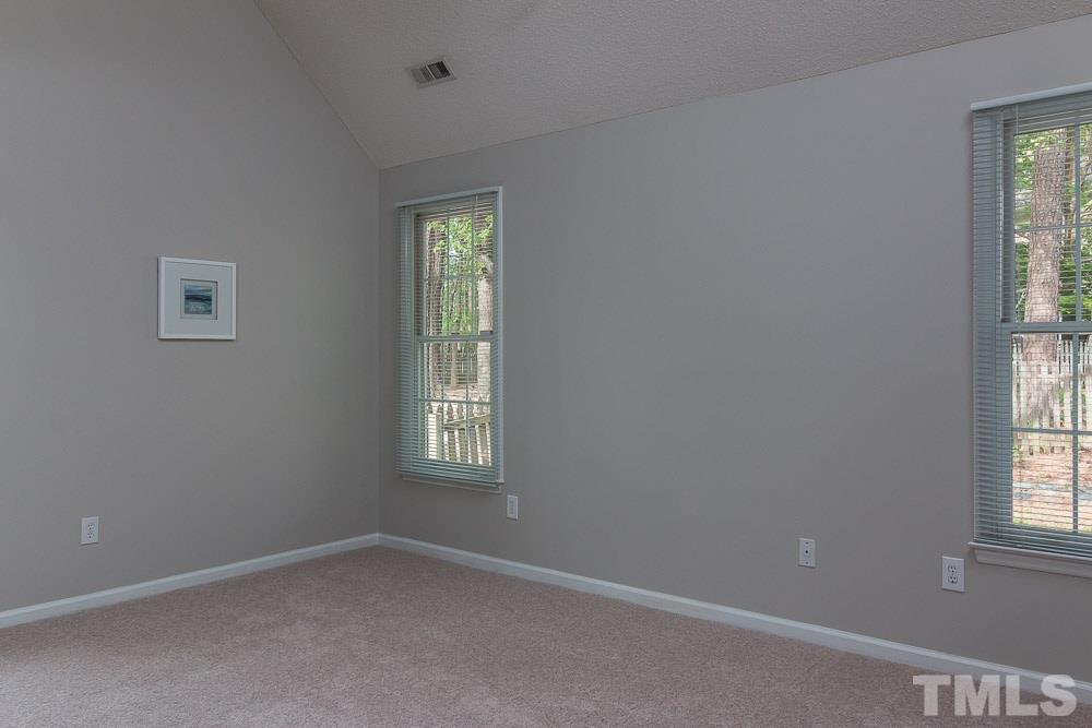 12404 Harcourt Drive Raleigh, NC 27613 - Photo 10 of 22 an empty room with windows and chandelier fan