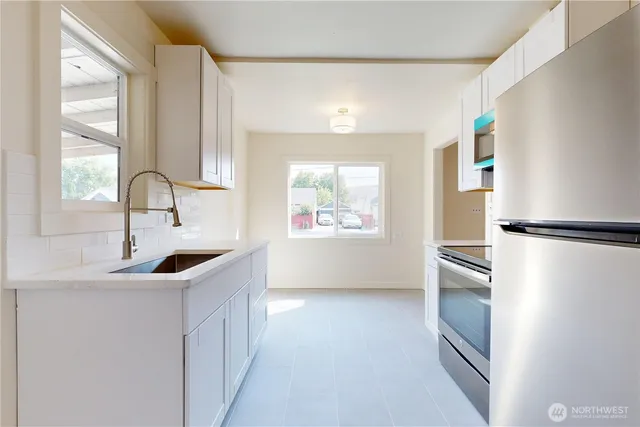 a kitchen with stainless steel appliances granite countertop a sink and a refrigerator