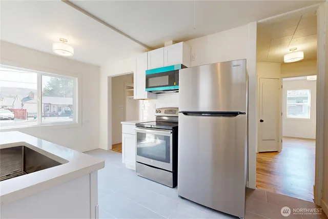 a kitchen with a refrigerator sink and cabinets