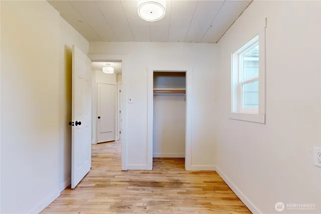an empty room with wooden floor and closet