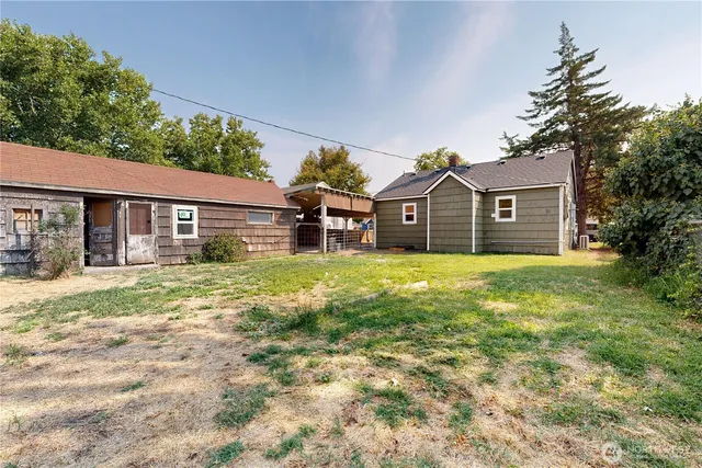 a view of a yard in front of a house with large trees