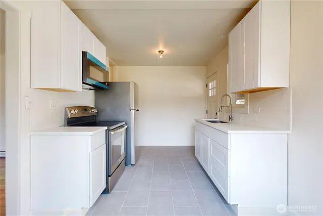 a kitchen with stainless steel appliances a sink and a refrigerator
