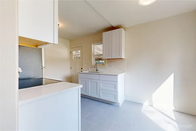 a kitchen with sink a microwave and cabinets