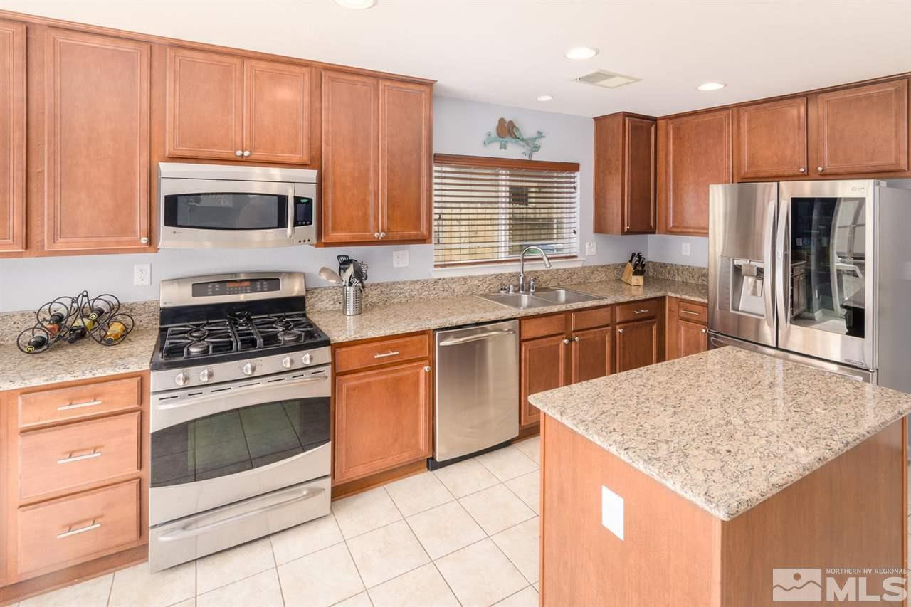 8924 Grisom Way Reno, NV 89506 - Photo 8 of 22 a kitchen with stainless steel appliances granite countertop a stove a sink dishwasher and a refrigerator