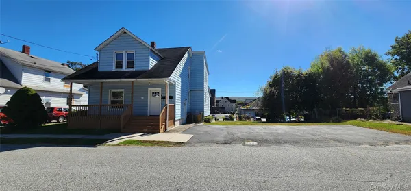 a view of a house with a yard next to a road