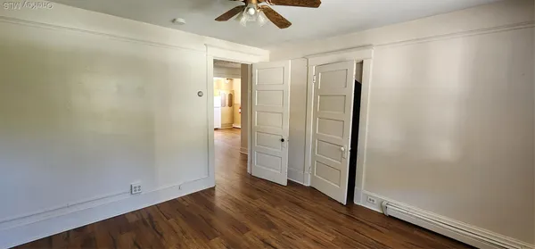 a view of empty room with wooden floor