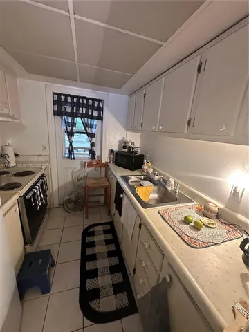 a kitchen with a sink a stove and cabinets