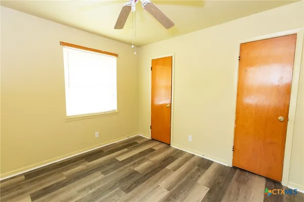 a view of a room with wooden floor and a window