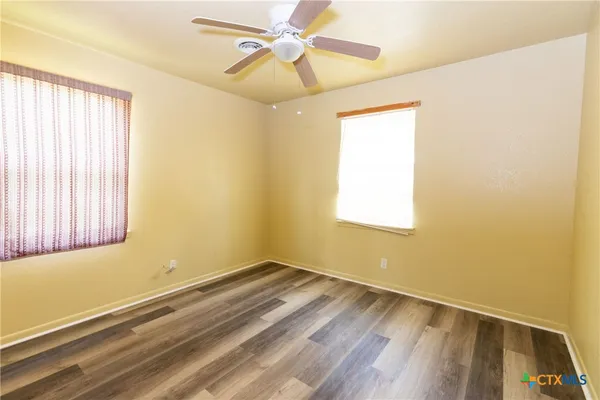 a view of a room with wooden floor and fan