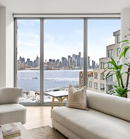 a living room with couches and a large window with garden view