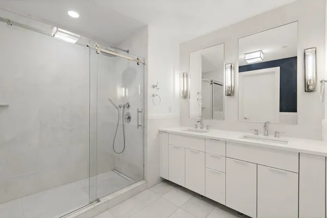 a bathroom with a double vanity sink mirror and shower