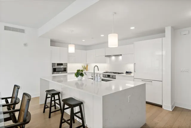 a kitchen with kitchen island a stove a table and chairs