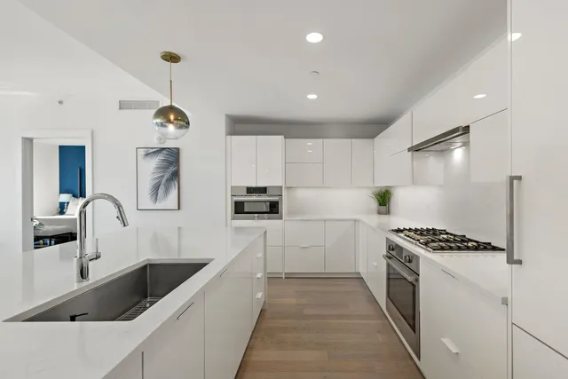 a kitchen with kitchen island stainless steel appliances a sink a counter and cabinets