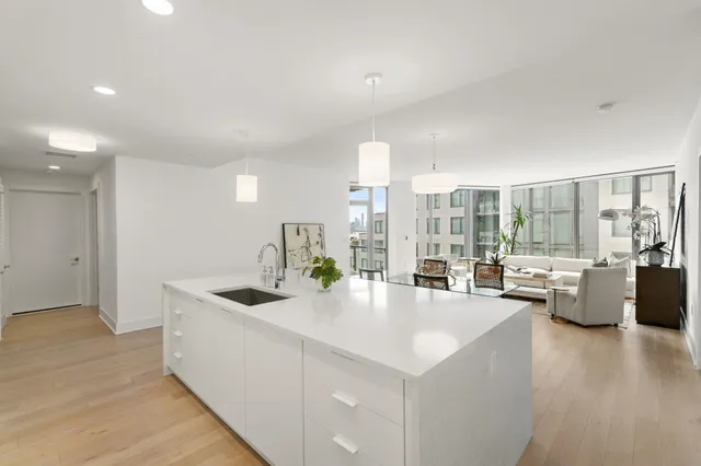 a large white kitchen with a large window and couch