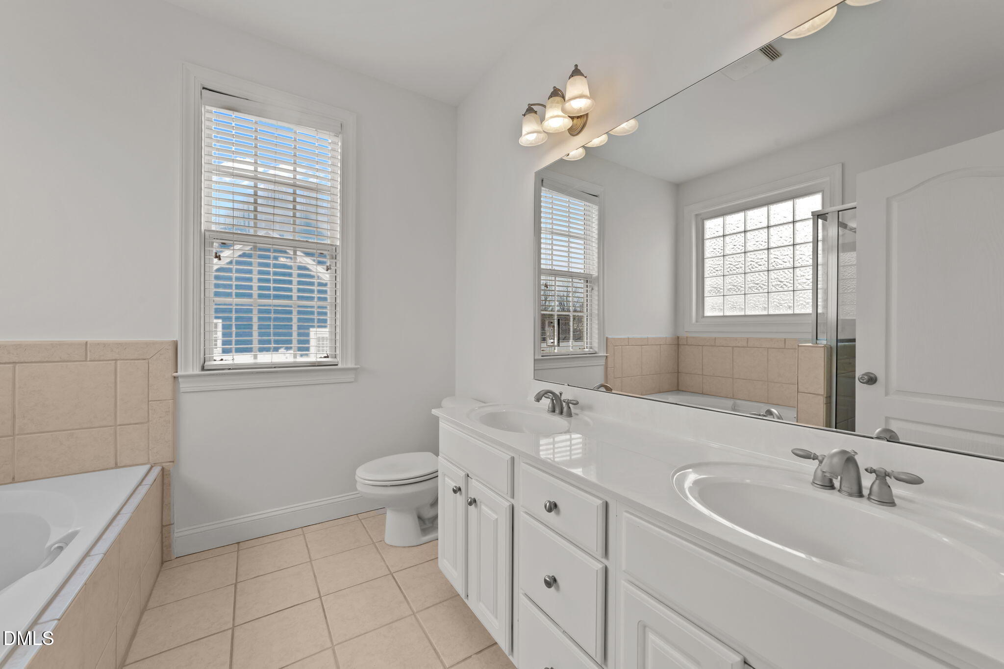 7101 Numa Circle Willow Spring, NC 27592 - Photo 17 of 44 a bathroom with double vanity sink a toilet a and a window