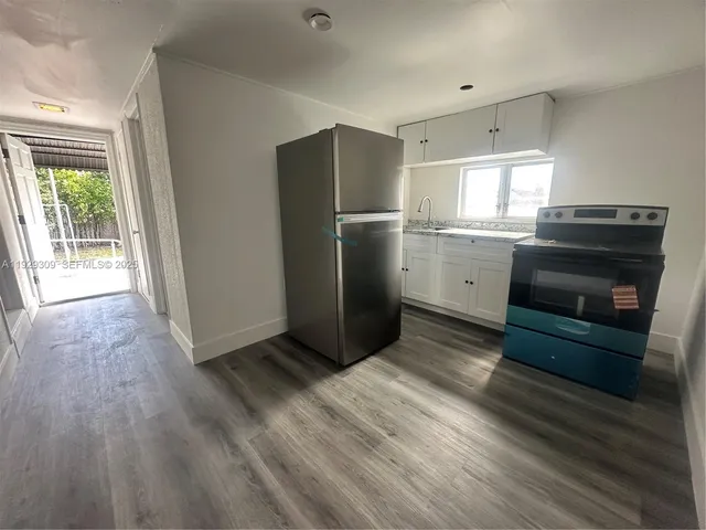 a kitchen with a refrigerator and a stove top oven