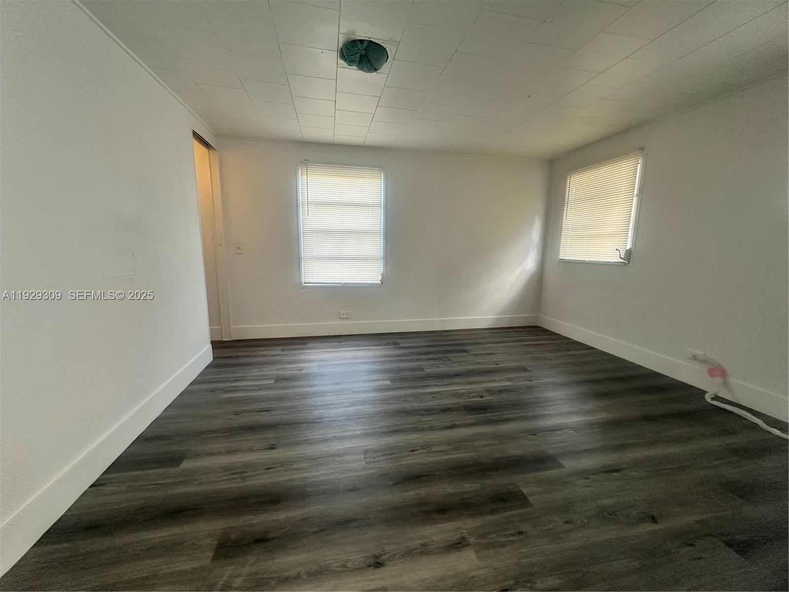 4762 Canal Road, Unit A1 West Palm Beach, FL 33415 - Photo 2 of 10 an empty room with wooden floor and windows