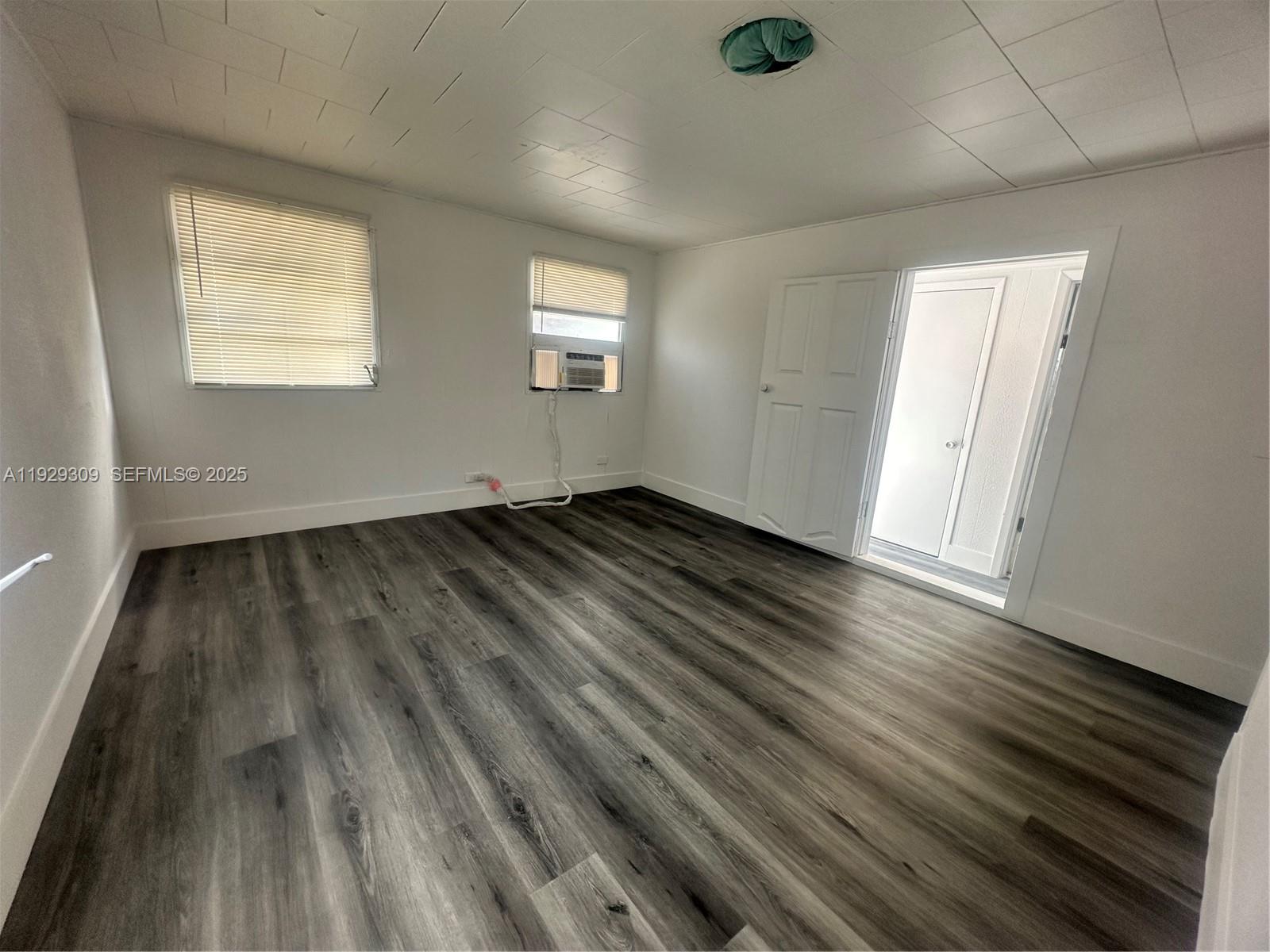 4762 Canal Road, Unit A1 West Palm Beach, FL 33415 - Photo 3 of 10 an empty room with wooden floor and windows