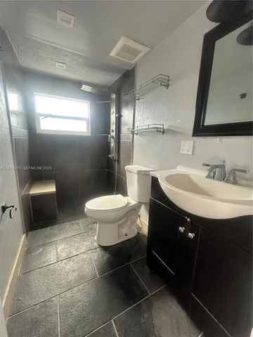 a bathroom with a sink toilet and mirror