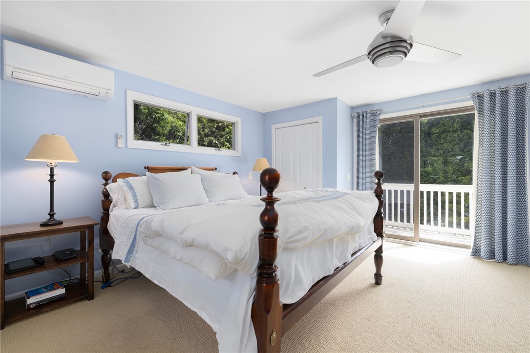 8 Schoolhouse Road Narragansett, RI 02882 - Photo 29 of 41 A spacious and relaxing primary bedroom. The deck off the sliders is perfect for morning coffee and peaceful views to start your day.