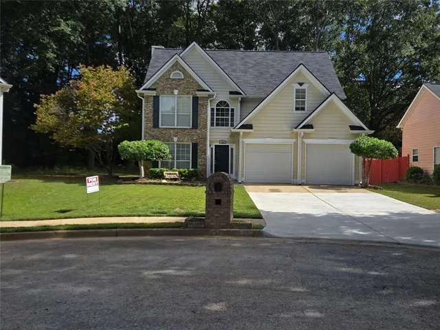 a front view of a house with a yard and garage