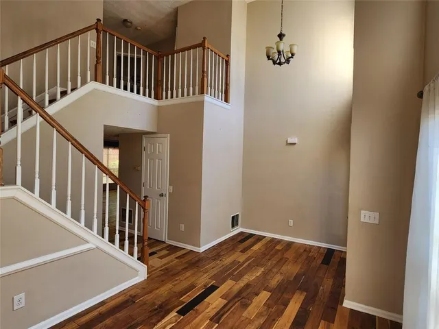 a view of staircase with lots of frames on wall and a window