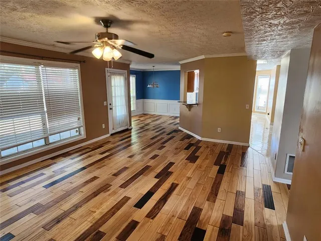 a view of a hallway with wooden floor and entryway