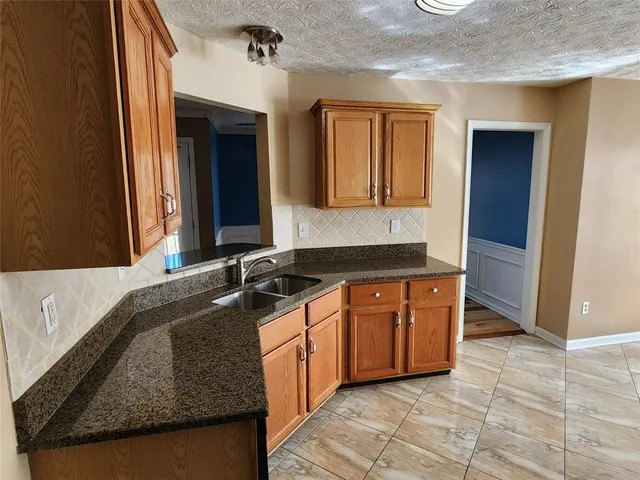 a kitchen with stainless steel appliances granite countertop a refrigerator and a stove