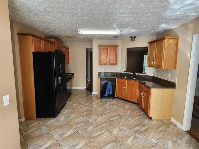 a kitchen with stainless steel appliances granite countertop a refrigerator and a stove