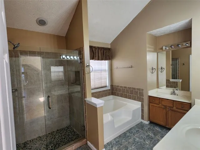 a bathroom with a bathtub shower sink and mirror