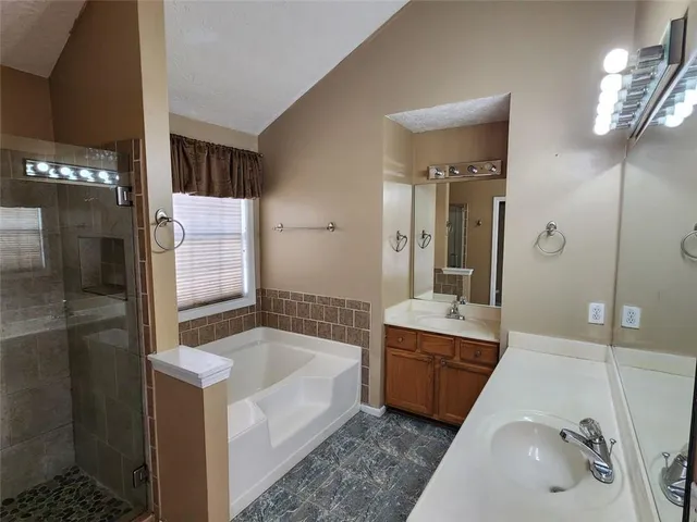 a bathroom with a tub sink and mirror