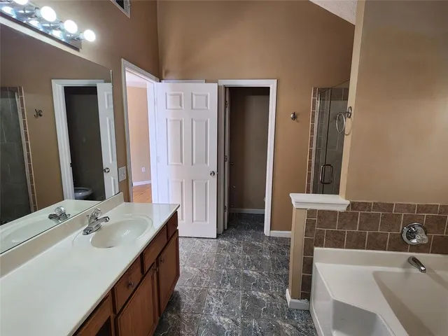 a bathroom with a tub sink and mirror