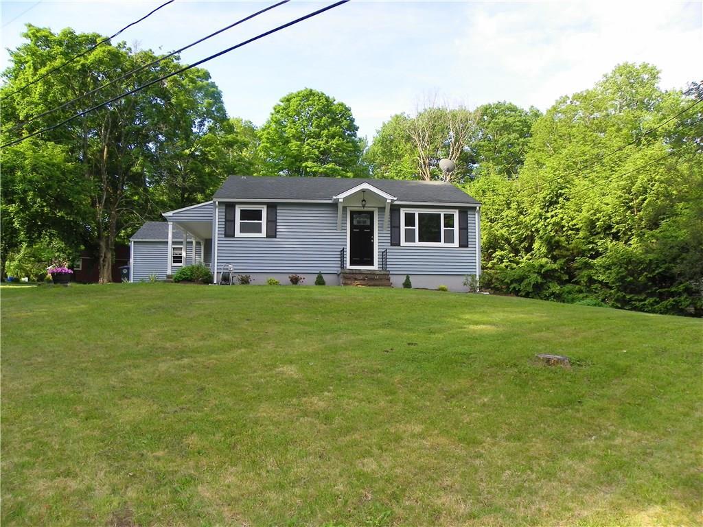 a house that is sitting in the grass with tress in the background
