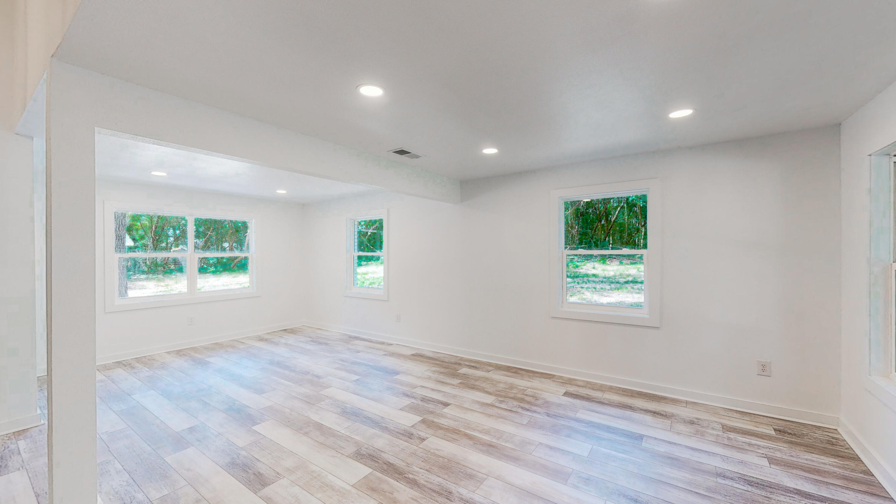 2522 Kingston Road Crestview, FL 32536 - Photo 24 of 43 an empty room with wooden floor and windows