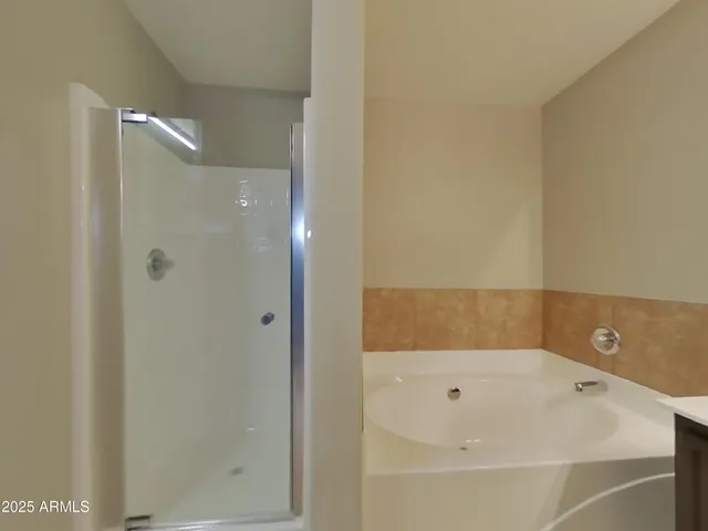 a bathroom with a tub a sink and mirror
