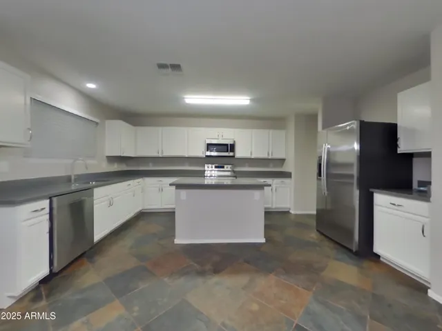 a kitchen with stainless steel appliances granite countertop a sink and stove top oven