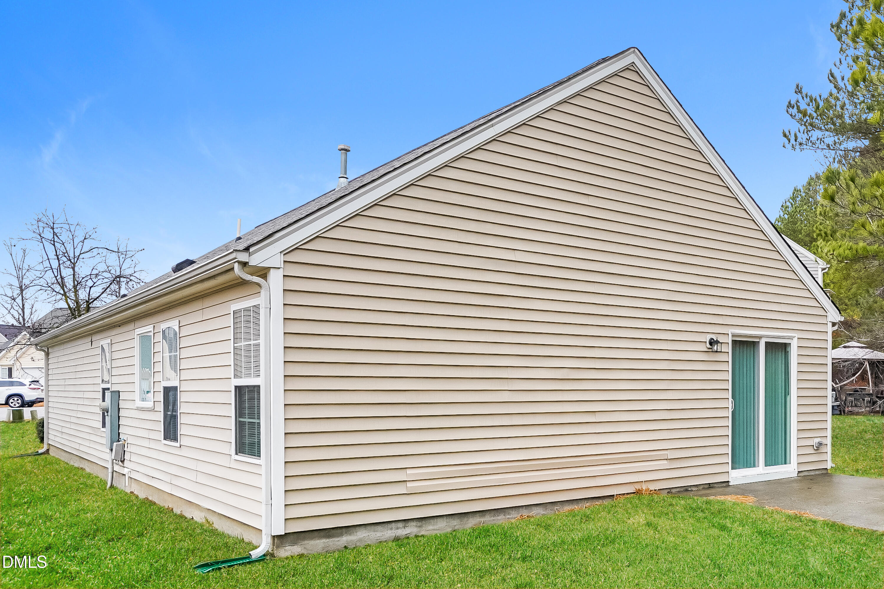 3405 Mogollon Court Raleigh, NC 27610 - Photo 15 of 16 a view of a white house with a small yard and a large tree
